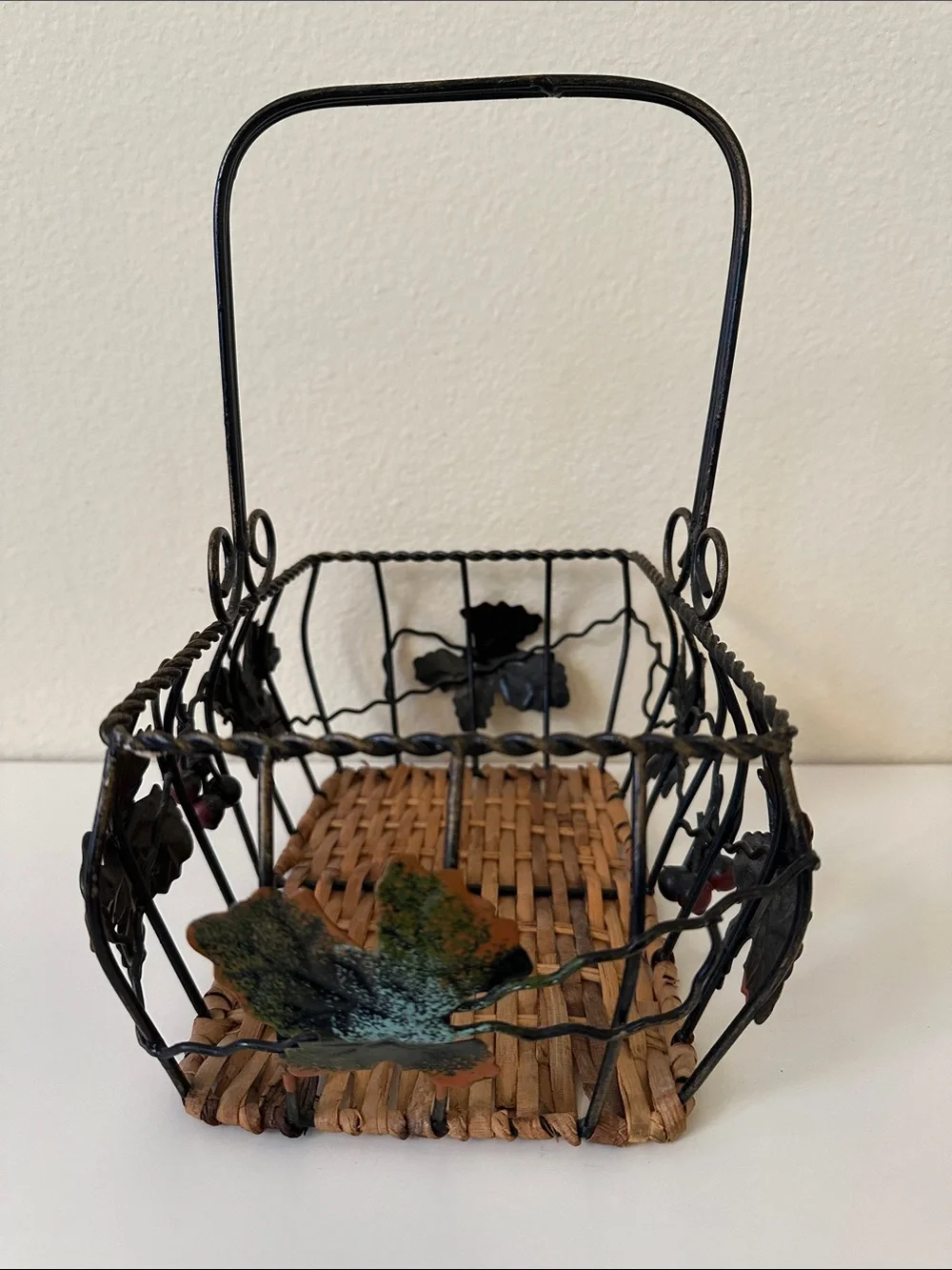 Black Metal and Brown Woven Decorative Basket with Green Leaf Accents